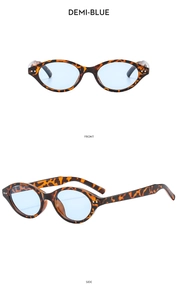 Macro view of retro demi-blue oval sunglasses with silver studs and light blue lenses