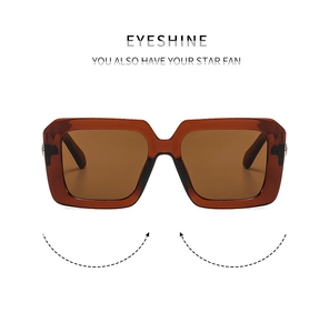 Detail of square amber tortoiseshell sunglasses with translucent frame and brown lenses
