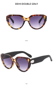 Detail view of tortoiseshell cat-eye sunglasses with purple gradient lenses and wide temples