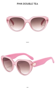Detail of pink cat-eye sunglasses featuring golden waterdrop accents and tea gradient lenses