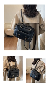 Detalle de mochila vintage negra en cuero sintético con hebillas doradas y cremallera