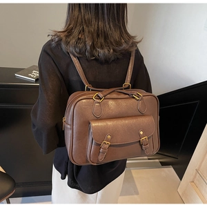 Detailed back view of a vintage brown PU leather college style backpack and handbag