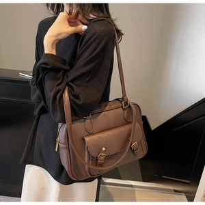 Detail of vintage brown PU leather briefcase bag with metal buckle on a model
