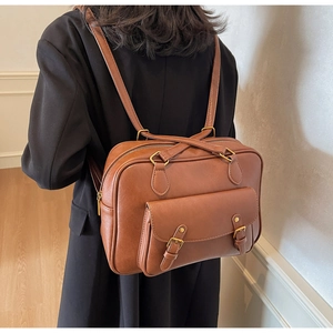Brown vintage PU leather multi-purpose backpack shown on model with dual buckle details