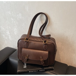 Detailed view of deep brown vintage leather shoulder bag with antique bronze buckles