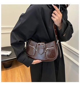 Detailaufnahme der tiefbraunen Lackleder-Unterarmtasche mit Zierschnalle und Taschen