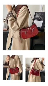 Makro-Detail einer roten Vintage-Schultertasche mit silbernen Schnallen und Reißverschluss