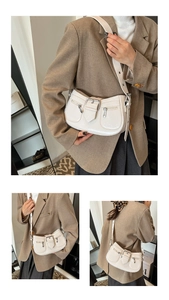 Detailansicht der cremefarbenen Vintage-Tasche mit glänzendem Finish und Metall-Reißverschlüssen