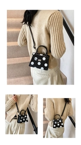Detailed view of polka dot crossbody bag with gold twist lock and elegant bow accent