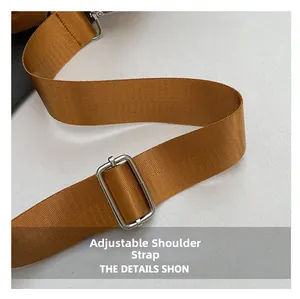Κοντινό πλάνο με ρυθμιζόμενο νάιλον λουράκι ώμου σε καφέ χρώμα και ασημένια αγκράφα