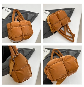 Detail view of brown quilted puffer shoulder bag with adjustable strap and metal buckles