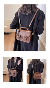 Detail of vintage brown leather satchel showing multi-way straps and buckle texture