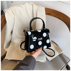 Polished black crossbody bag with white polka dots and silver twist lock detail