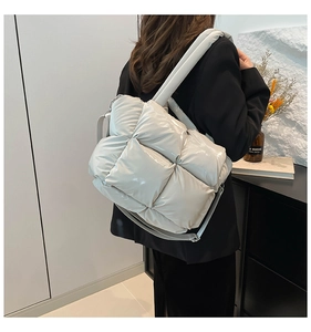 Quilted puffer shoulder bag in off-white glossy finish shown on a female model