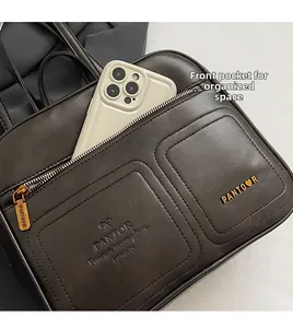 Detailansicht der Vordertasche mit Logo-Prägung und Smartphone an dunkelbrauner Ledertasche