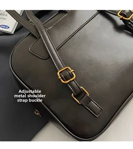 Detail der verstellbaren goldfarbenen Metallschnalle und Nähte der dunkelbraunen Tasche