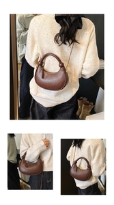 Detailed view of dark brown crescent bag with arched handle and gold chain strap