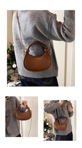 Detail view of brown crescent bag with gold chain strap and integrated round handle