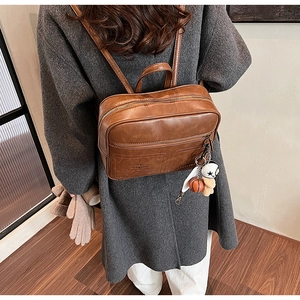 Detail view of brown vintage PU leather backpack with PANYON logo and basketball charm