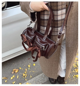 Détail du sac bowling marron foncé avec nœuds en ruban et poches utilitaires