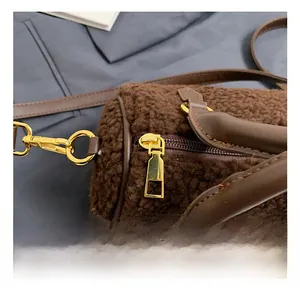 Close-up of golden zipper hardware and brown plush texture on the Boston bag