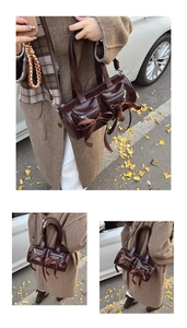 Détail du sac cylindre en cuir verni marron foncé avec nœuds et poches zippées