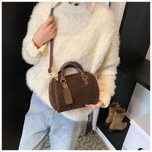 Detailed view of dark brown plush Boston bag styled with a white sweater and jeans