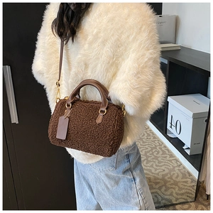 Detail of plush dark brown Boston bag with teddy fleece texture and gold metal hardware
