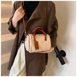 Détail du mini sac Boston en peluche crème avec lanières en cuir marron foncé