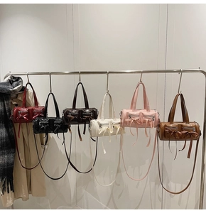 Détail de sacs cylindriques multicolores avec rubans à nœuds et doubles fermetures