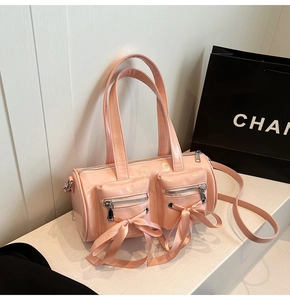 Détail du sac baril en cuir verni rose avec nœuds en ruban et fermetures argentées