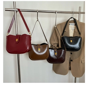 Nahaufnahme von Retro-Satteltaschen in Burgunder, Braun, Beige und Schwarz mit Goldschließe
