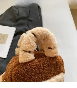 Detail of plush lambskin tote bag with fuzzy beige handle and brown fleece texture