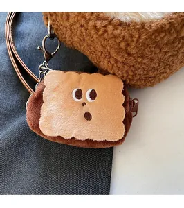 Detailed view of a plush toast-shaped charm with embroidery and zipper on a brown bag