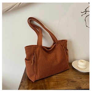Nahaufnahme der Cord-Tasche in Dunkelorange mit seitlichem Kordelzug und weicher Textur