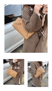 Detail of light brown pleated tote bag with wavy stitching and side drawstring design