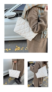 Detail of white quilted tote bag featuring plush rhombic patterns and slender shoulder straps