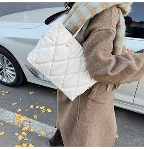 Chic white quilted tote bag in a street style setting with a brown autumn coat