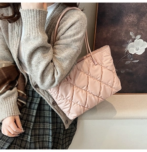 Detail of pink quilted tote bag with soft diamond stitching and lightweight nylon texture