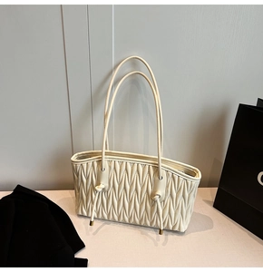 Detail of off-white quilted tote bag with pleated texture and decorative knot drawstring