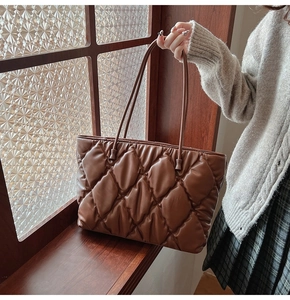 Detailed view of the brown quilted tote bag with large diamond stitch and plush texture