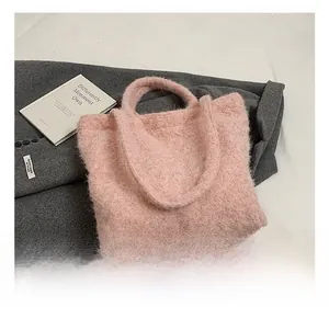 Détail du sac cabas en peluche rose montrant la fausse fourrure et la poignée souple
