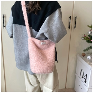 Détail d'un sac seau en peluche rose avec fausse fourrure douce et étiquette tissée