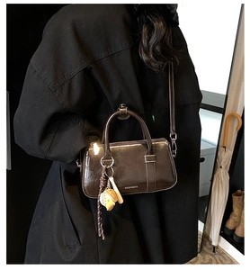 Détail du sac à main vintage en cuir ciré marron avec pendentif de baseball