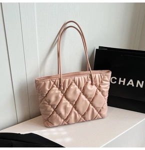 Close-up of pink quilted tote bag with padded texture and slim shoulder straps