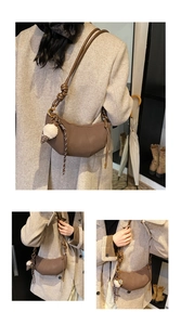 Detail of dark brown crescent bag featuring vertical quilting and plush charm accessory
