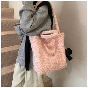 Détail d'un sac cabas en peluche rose avec texture douce et bandoulières souples