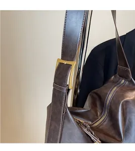 Detail of adjustable shoulder strap with vintage metal buckle on coffee tote bag