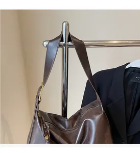 Detail of the durable shoulder strap and metal hardware on a brown tote bag