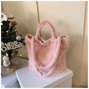 Détail d'un sac cabas en peluche rose avec deux anses sur un présentoir festif chic